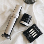 Coravin wine preservation system, black canister, and a box of three sparkling wine gas cartridges on a white cloth background.