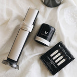 Coravin wine preservation system, black canister, and a box of three sparkling wine gas cartridges on a white cloth background.