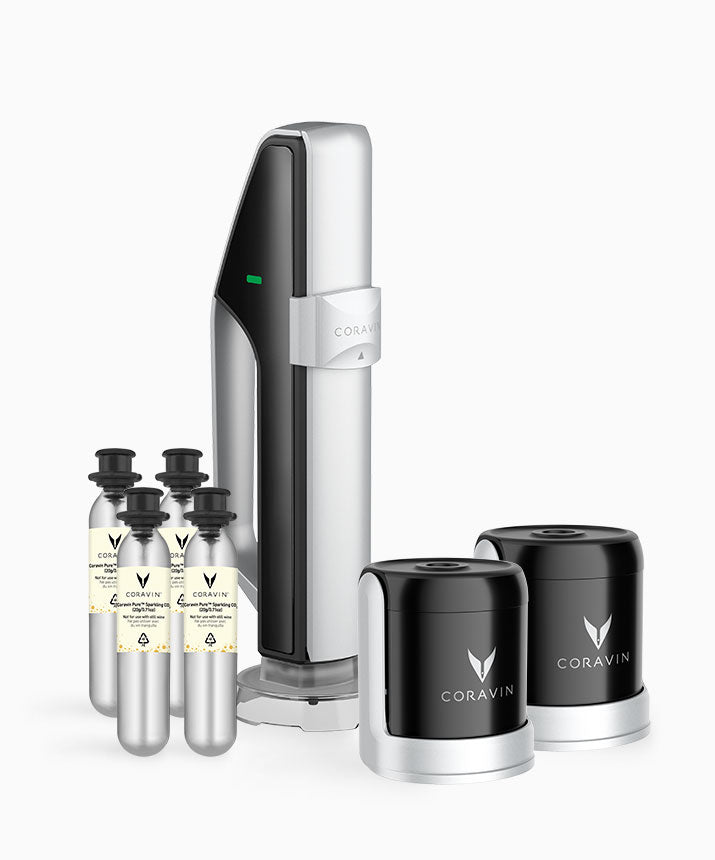Coravin wine preservation system featuring a silver device and two black capsules, with three small gas canisters.