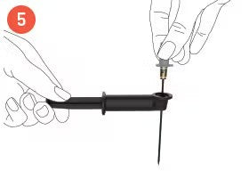 Step 5: Hands holding a tool with a pin, attaching a component to the end of the black handle.