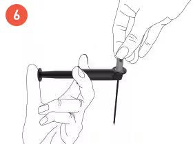 Instruction step six: A hand demonstrates how to use a Coravin needle-like device while holding a small cap with the other hand.