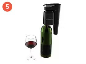 Electric wine aerator beside a wine bottle and a glass filled with red wine.