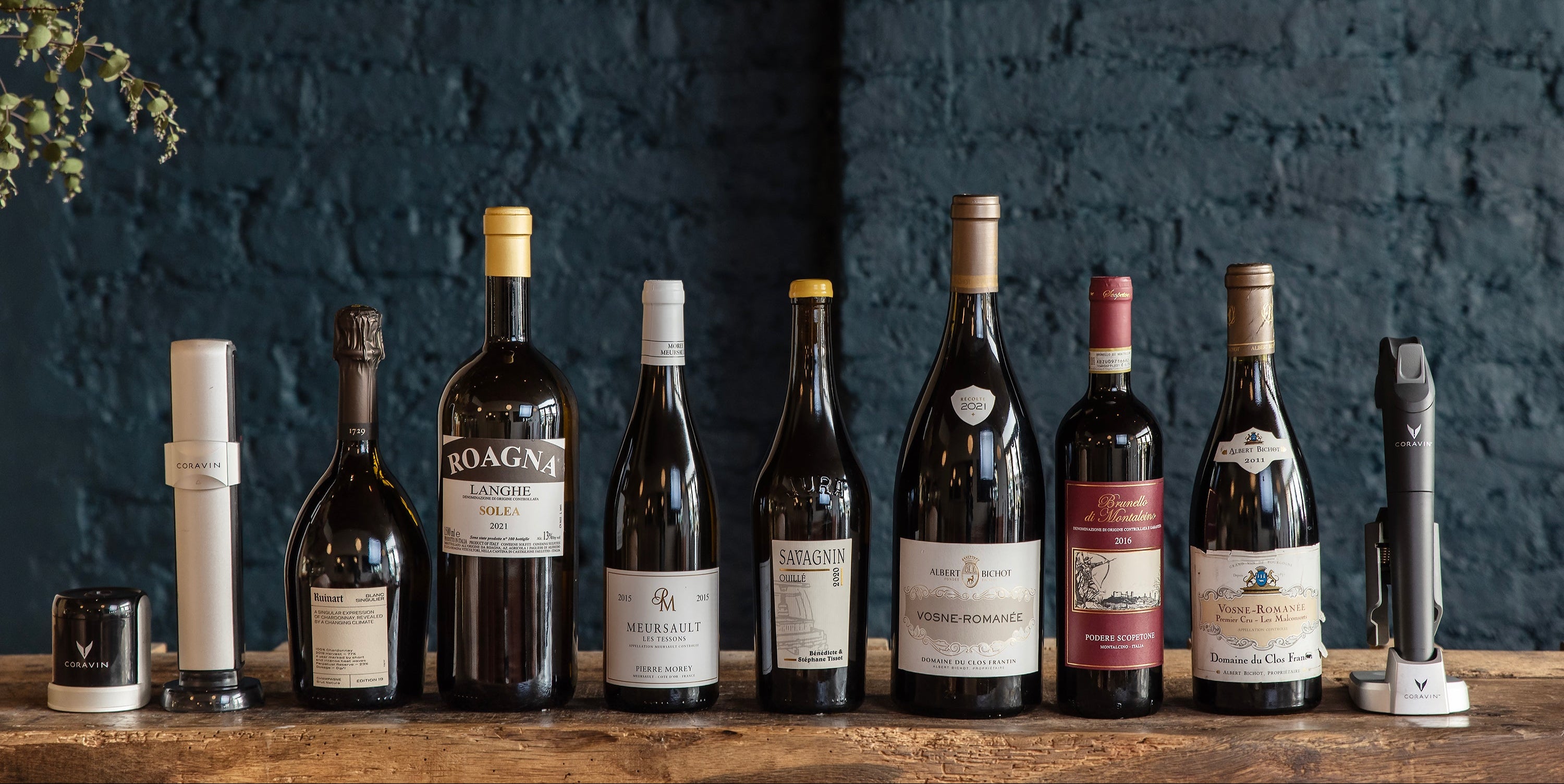 coravin sparkling and coravin pivot with a line of wines against a dark blue brick wall